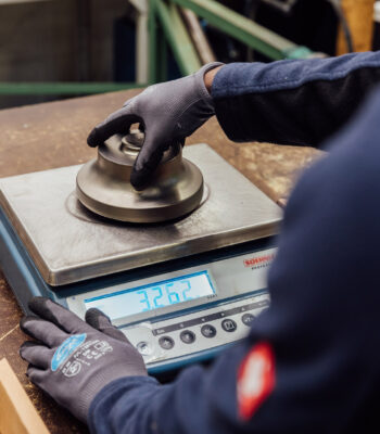An employee weighing a raw material for automotive compressors. An employee weighing a raw material for automotive compressors.