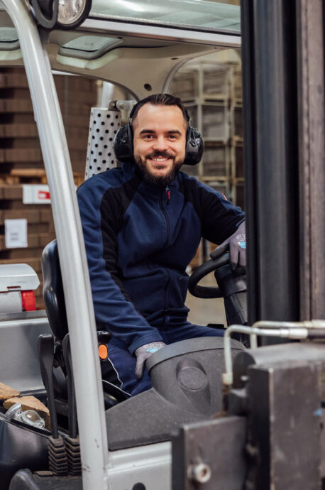 An employee sits in the forklift truck.