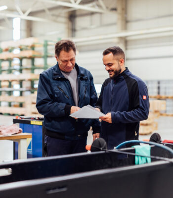 Two colleagues check a document.